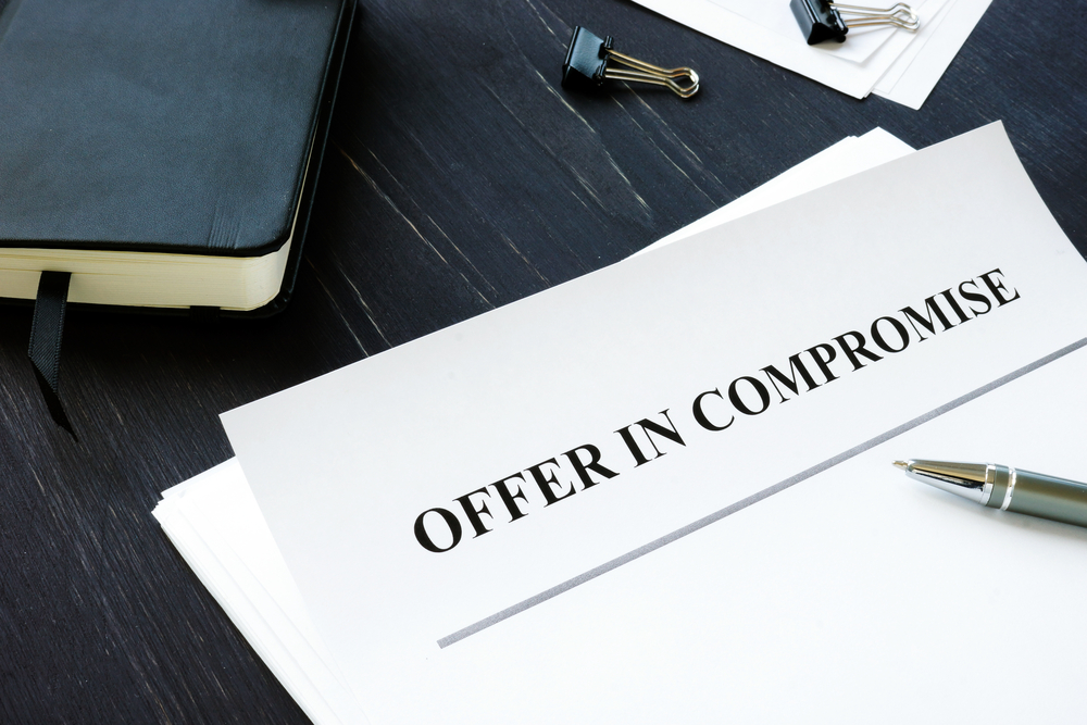 Offer in compromise papers on desk with pen