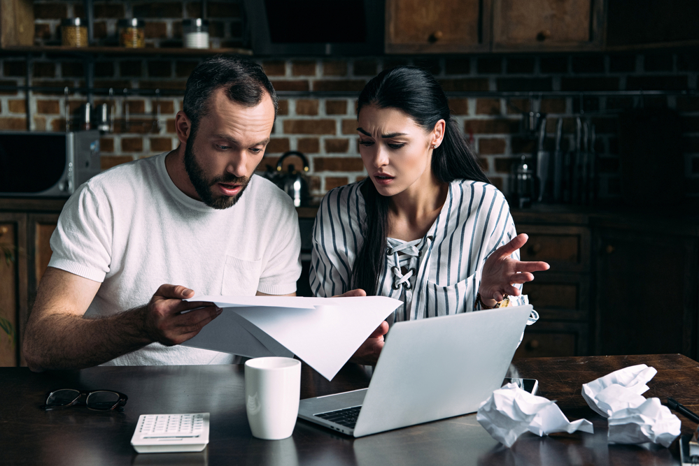 Husband and wife looking at papers in shock