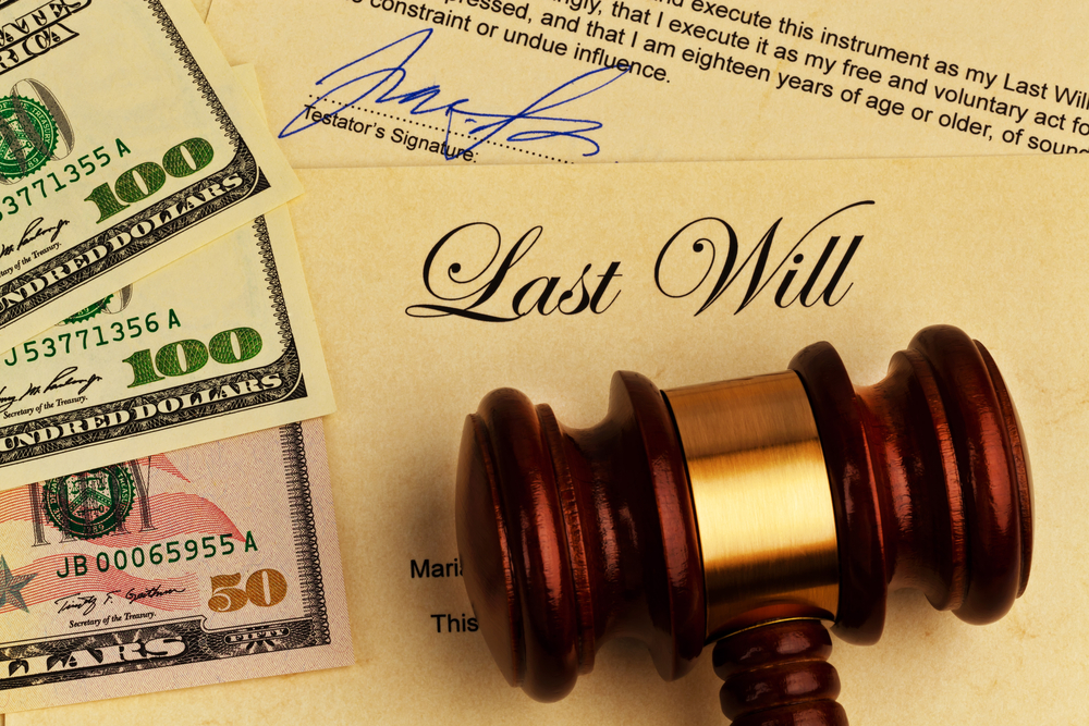 Last will documents with judge's gavel and $100 bills on top