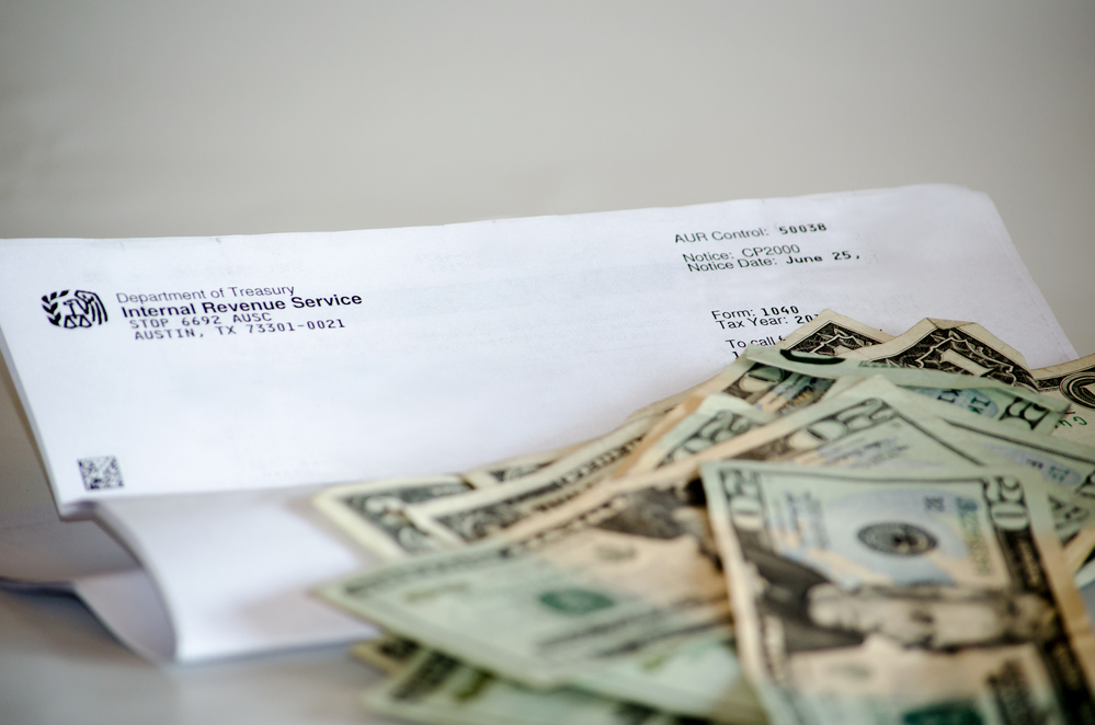 Folded IRS letter next to pile of money