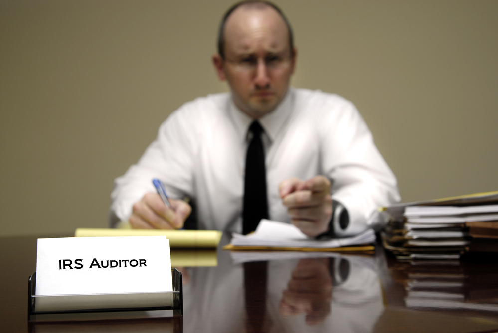 IRS auditor working on papers at desk